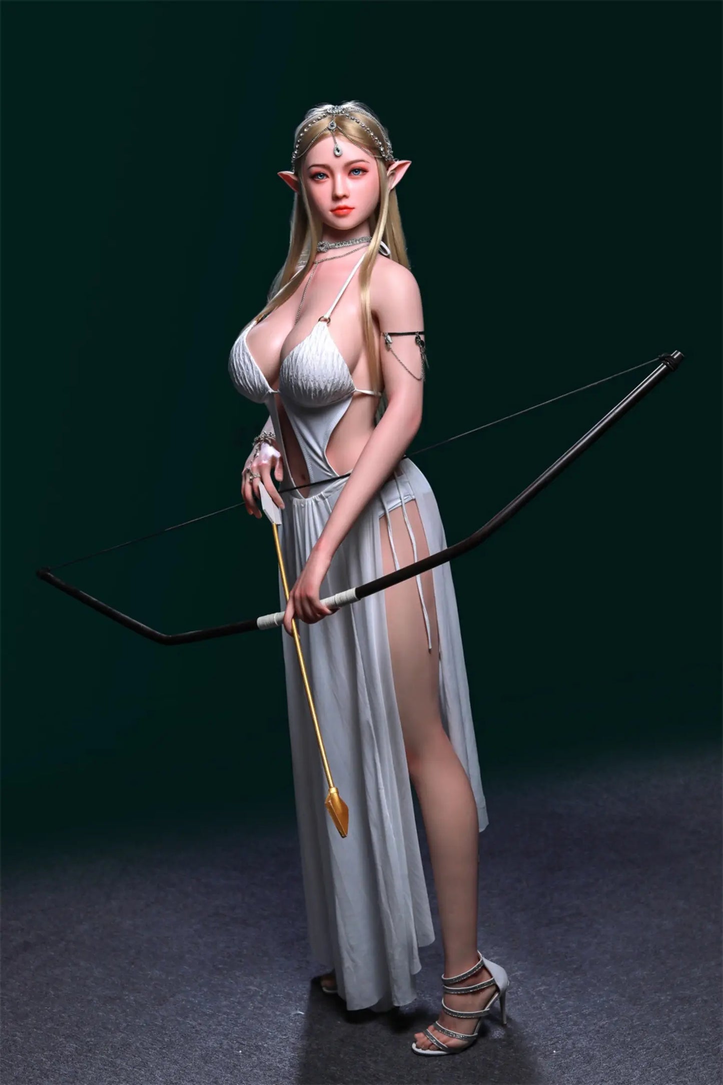 Akira sex doll fierce focused direct stare, pale green eyes with red-tinted eye shadow, long straight platinum blonde hair, pointed elf ears, ornate silver crystal chain headpiece with teardrop pendant, silver diamond choker necklace with layered chain body jewelry, white textured halter bikini top with massive full heavy breasts and deep natural cleavage, white sheer draped maxi skirt with front slit exposing long bare leg, silver upper arm chain cuff, both hands holding black recurve bow with gold arrow n