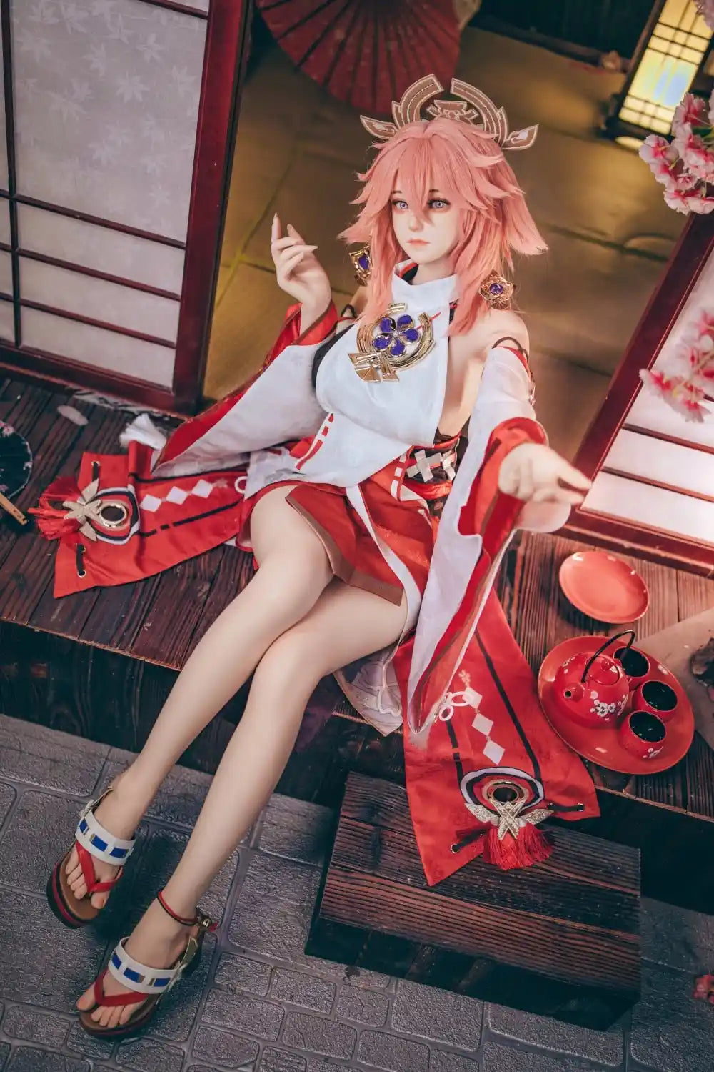  Yae Miko Genshin Impact cosplay sex doll, pink hair, sensual miko outfit, tatami room red cup – anime cosplay lifesize doll by TopLoveDoll,  red bell anklet, wooden geta sandals, Genshin Impact sex doll, sitting on the floor, holding a J-style red cup, high-angle bust shot