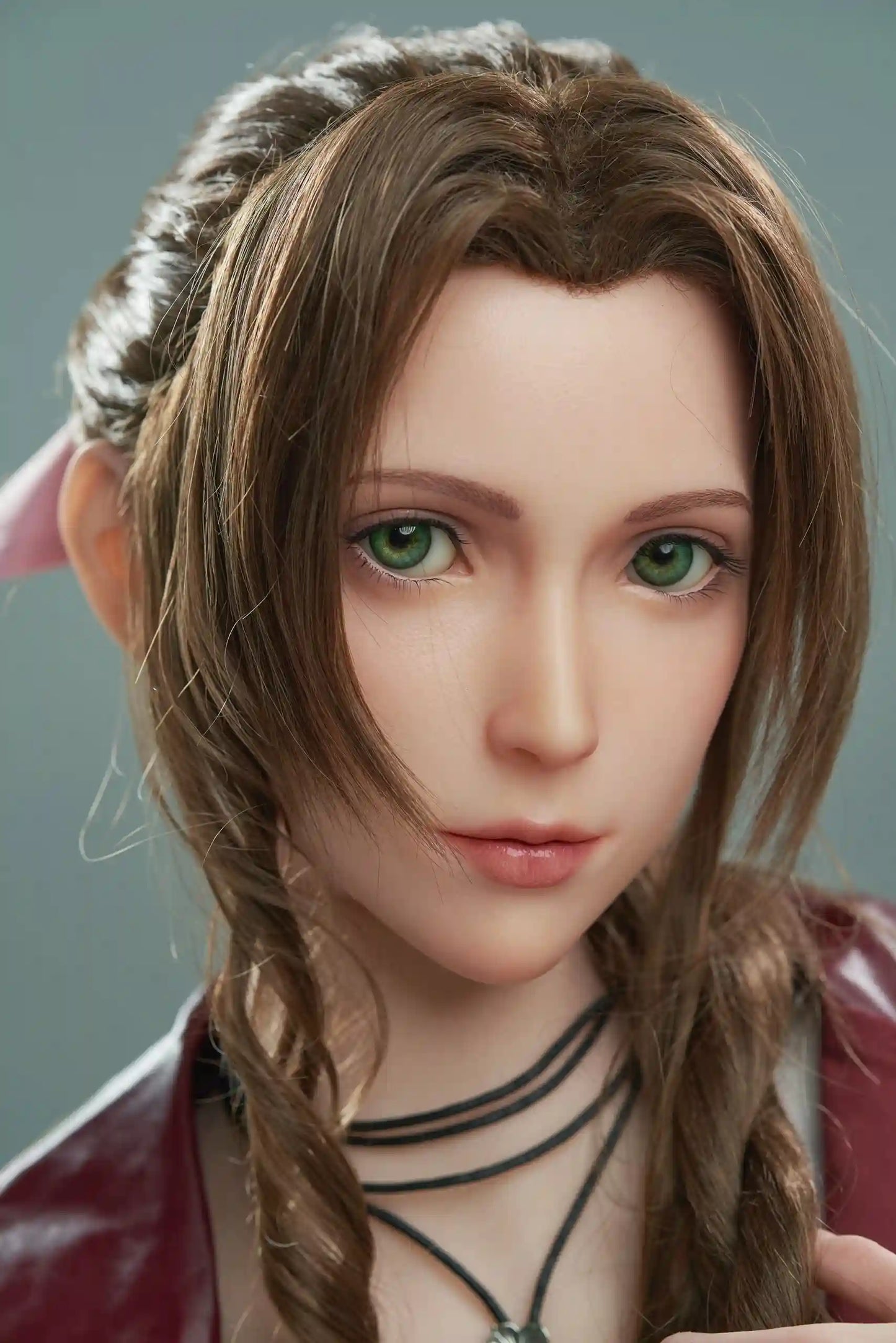 Seyo, brown wavy twin braids, pink hair bow, burgundy leather jacket, white deep-V slip dress, black leather mid-calf boots, green eyes, layered leather string choker, golden layered bracelet, looking at the camera like curious, grey studio background, face close-up – Tifa Lockhart cosplay sex doll by TopLoveDoll
