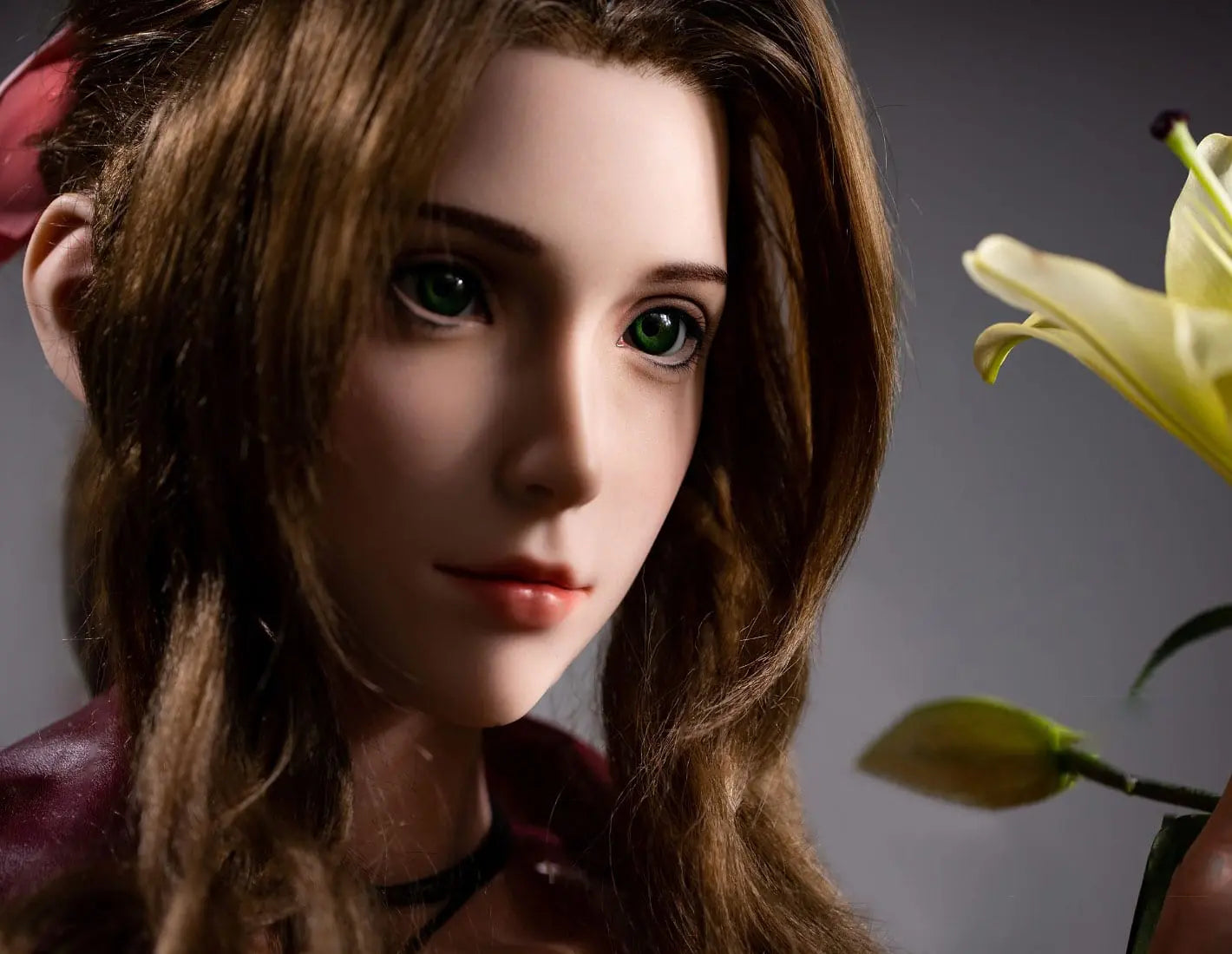 Hera, iconic green eyes, dark brown long curls hair, dark red suede jacket, white V-neck slip dress, pink bow, black choker, grey studio lighting background, appreciating a branch of lily– European bookish bombshell companion sex doll by TopLovedoll