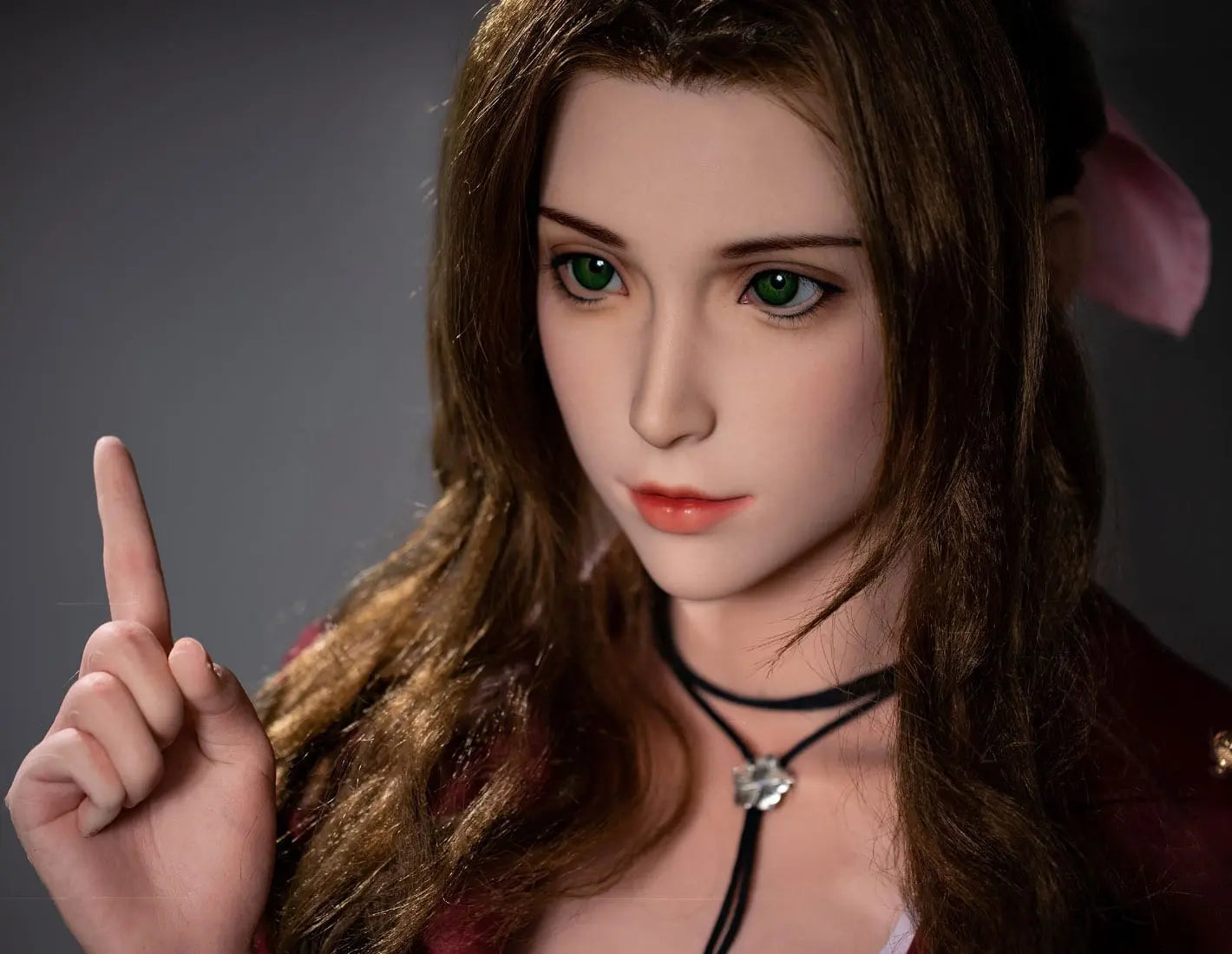 Hera, iconic green eyes, dark brown long curls hair, dark red suede jacket, white V-neck slip dress, pink bow, black choker, grey studio lighting background, pointing one finger up, close up– European bookish bombshell companion sex doll by TopLovedoll