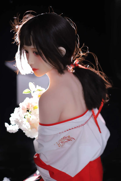 Ethereal maiden, Aleena, black princess cut half-up hair, wind blowing up her hair, white miko top, red hakama floral folding fan, dark shrine backdrop, backlit shot, kneeling on the floor, holding some white flowers, 45-degree back view – Japanese miko shrine maiden companion sex doll by TopLoveDoll