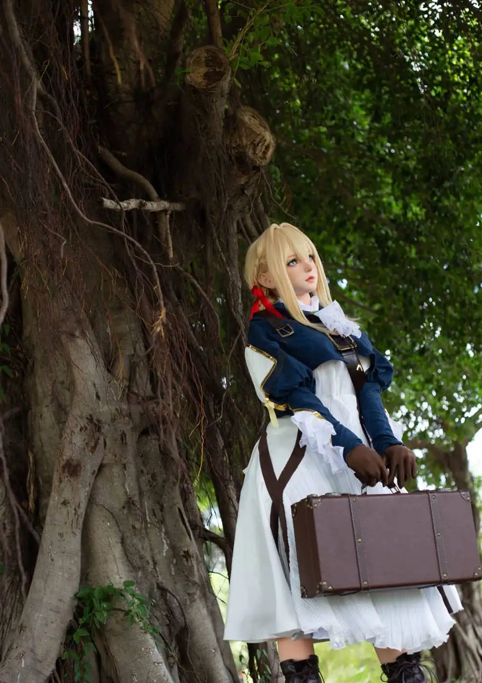 Aliana, golden straight long hair, blue eyes, navy Auto Memory Doll uniform, white apron, black leather boots, outdoor, green trees, standing, brown gloves, holding a brown leather suitcase, low-angle shot, side view – Violet Evergarden cosplay anime sex doll by TopLoveDoll