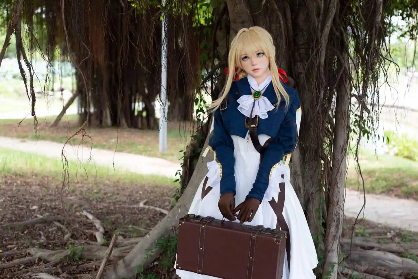 Aliana, golden straight long hair, blue eyes, navy Auto Memory Doll uniform, white apron, black leather boots, outdoor, green trees, standing in front of a tree with vines, brown gloves, holding a brown leather suitcase, eye-level shot, bust shot, front view, a higher contrast filter – Violet Evergarden cosplay anime sex doll by TopLoveDoll