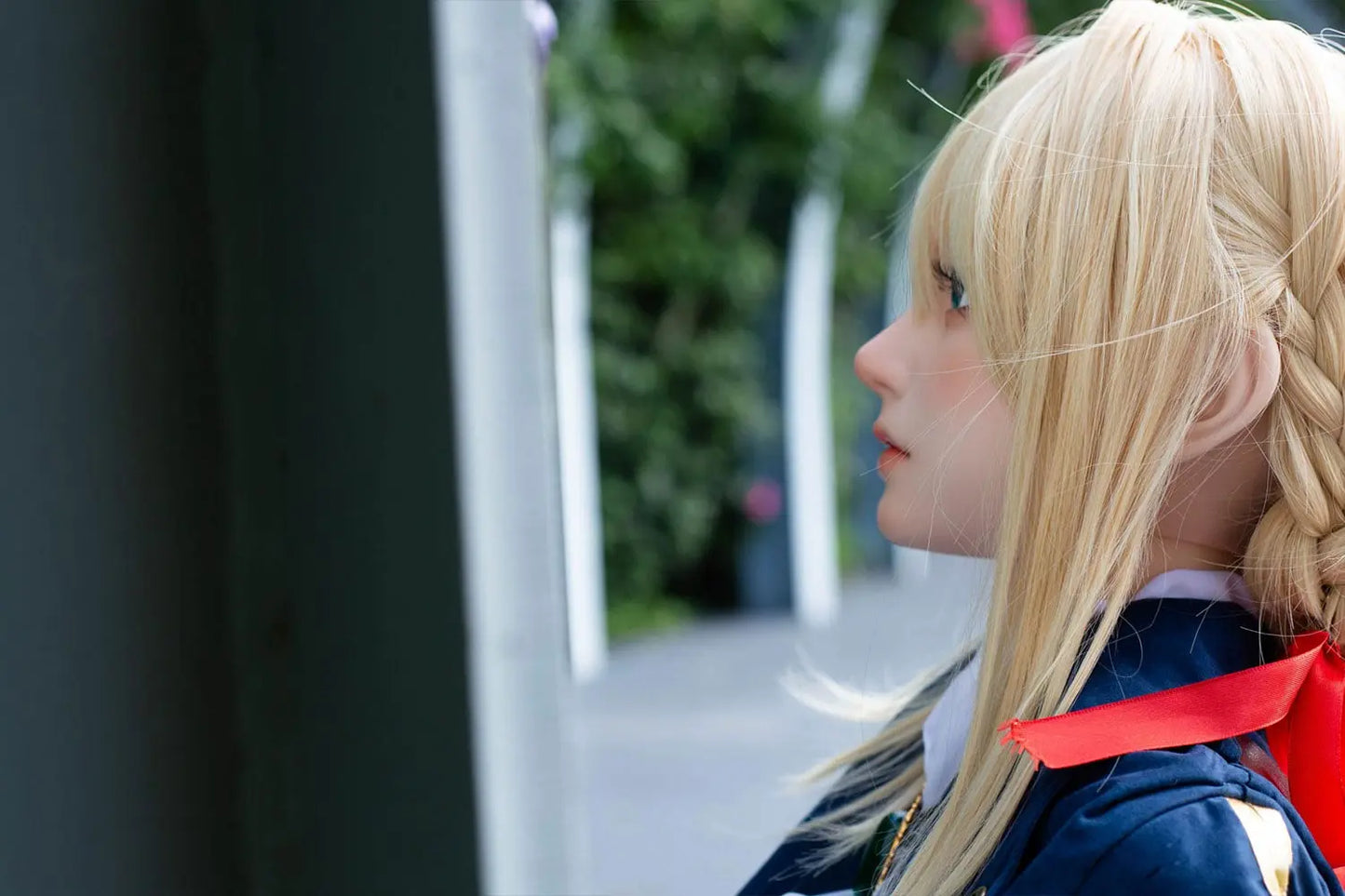 Aliana, golden straight long hair, blue eyes, navy Auto Memory Doll uniform, white apron, black leather boots, outdoor, brown gloves, holding a brown leather suitcase, eye-level shot, side face close up, look away, horizontal profile – Violet Evergarden cosplay anime sex doll by TopLoveDoll