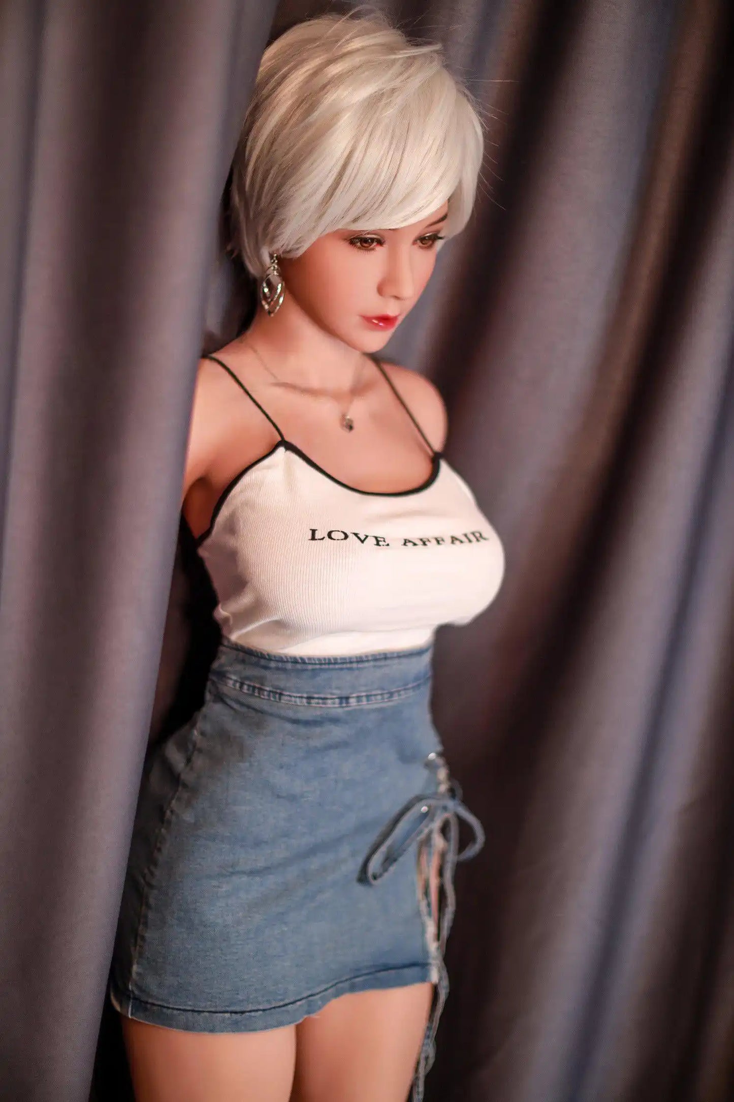 Anahi short platinum blonde hair tan skin white fitted tank denim micro skirt bold Shibuya street style pose, standing in front of the hotel curtain, side view – Asian blonde pornstar sex doll by TopLoveDoll
