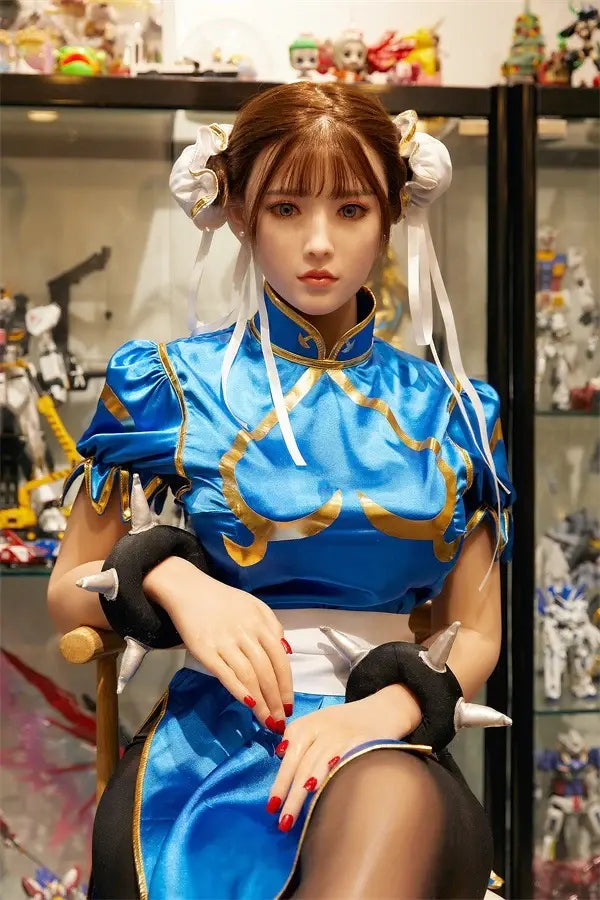 Araya Street Fighter Chun-Li cosplay sex doll, standing in front of her home figurine exhibits, grey contacts - blue qipao, high twin buns - Asian beauty elevated by TopLoveDoll