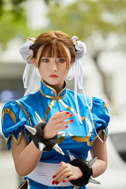 Araya Street Fighter Chun-Li cosplay sex doll, standing on a blurred park view background, grey contacts, spiky bracelets, red nails- blue qipao, high twin buns, - Asian beauty elevated by TopLoveDoll