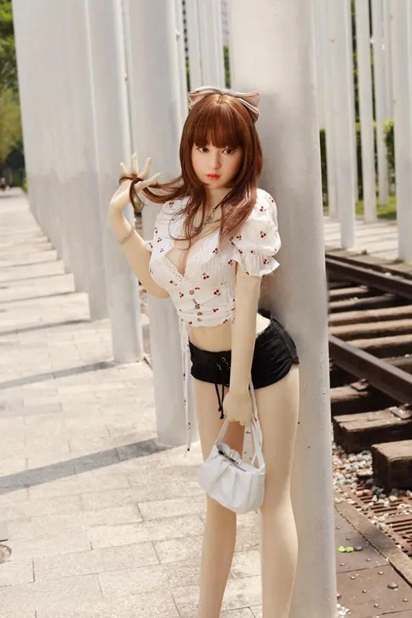 Arya high-maintenance Asian girlfriend sex doll- in cherry crop top and black denim shorts , standing against the pillar- sweet face impossible energy the one you can't quit by TopLoveDoll