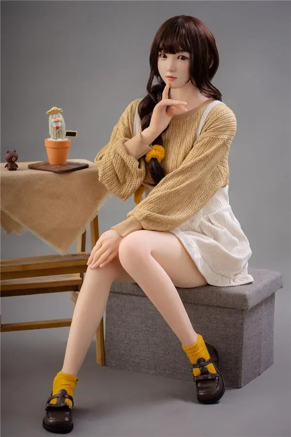 Astrid Asian bangs college sweetheart sex doll, sitting on the storage box chair, with her finger touching her chin like she's just got to notice that you arrived- first love high school girl next door by TopLoveDoll