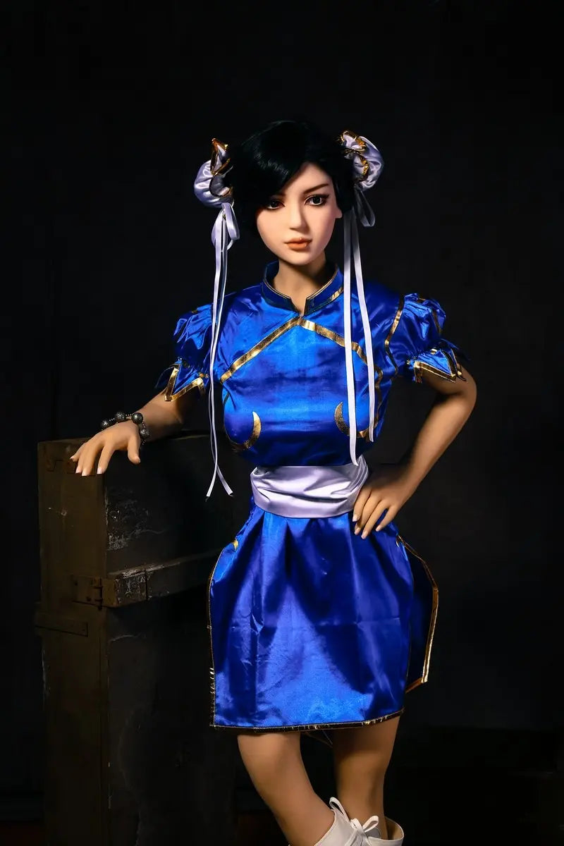 Aubriella Street Fighter Chun-Li cosplay sex doll in blue qipao on a black background, standing next to some wooden boxes - iconic blue qipao fighter fantasy by TopLoveDoll