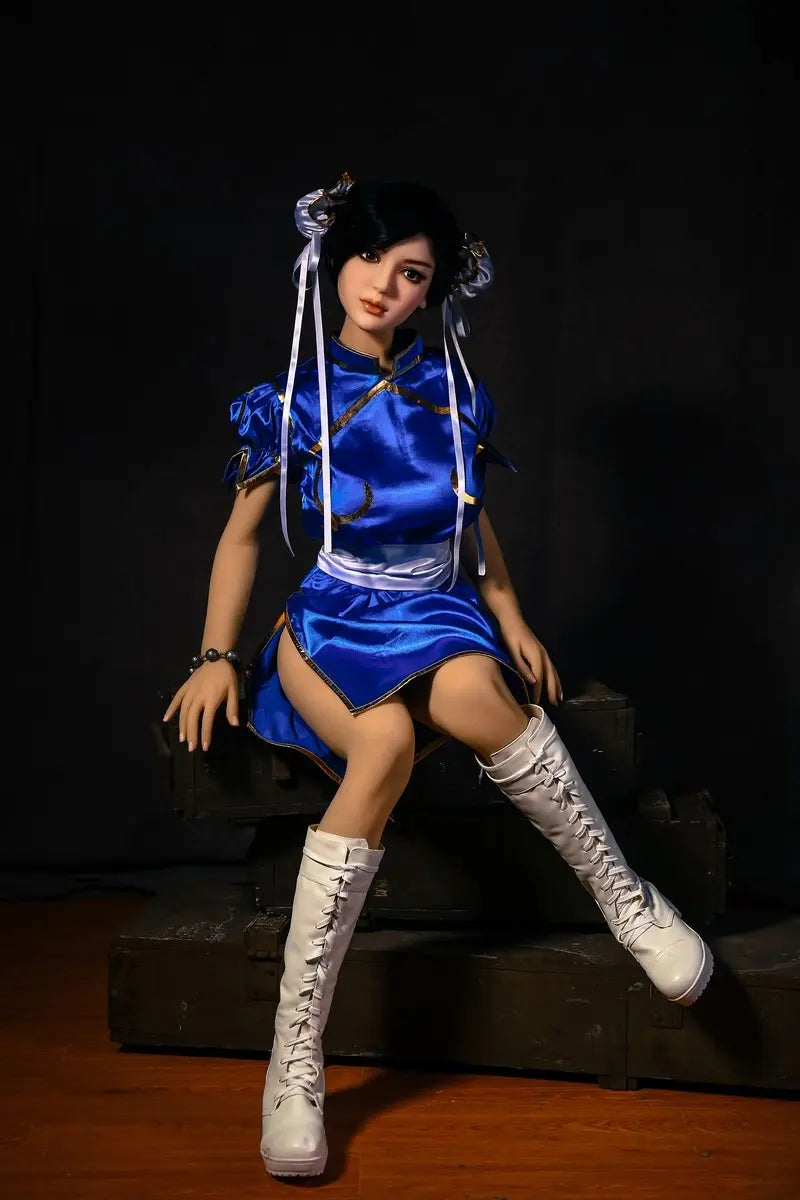 Aubriella Street Fighter Chun-Li cosplay sex doll in blue qipao on a black background, sitting on some wooden boxes - iconic blue qipao fighter fantasy by TopLoveDoll