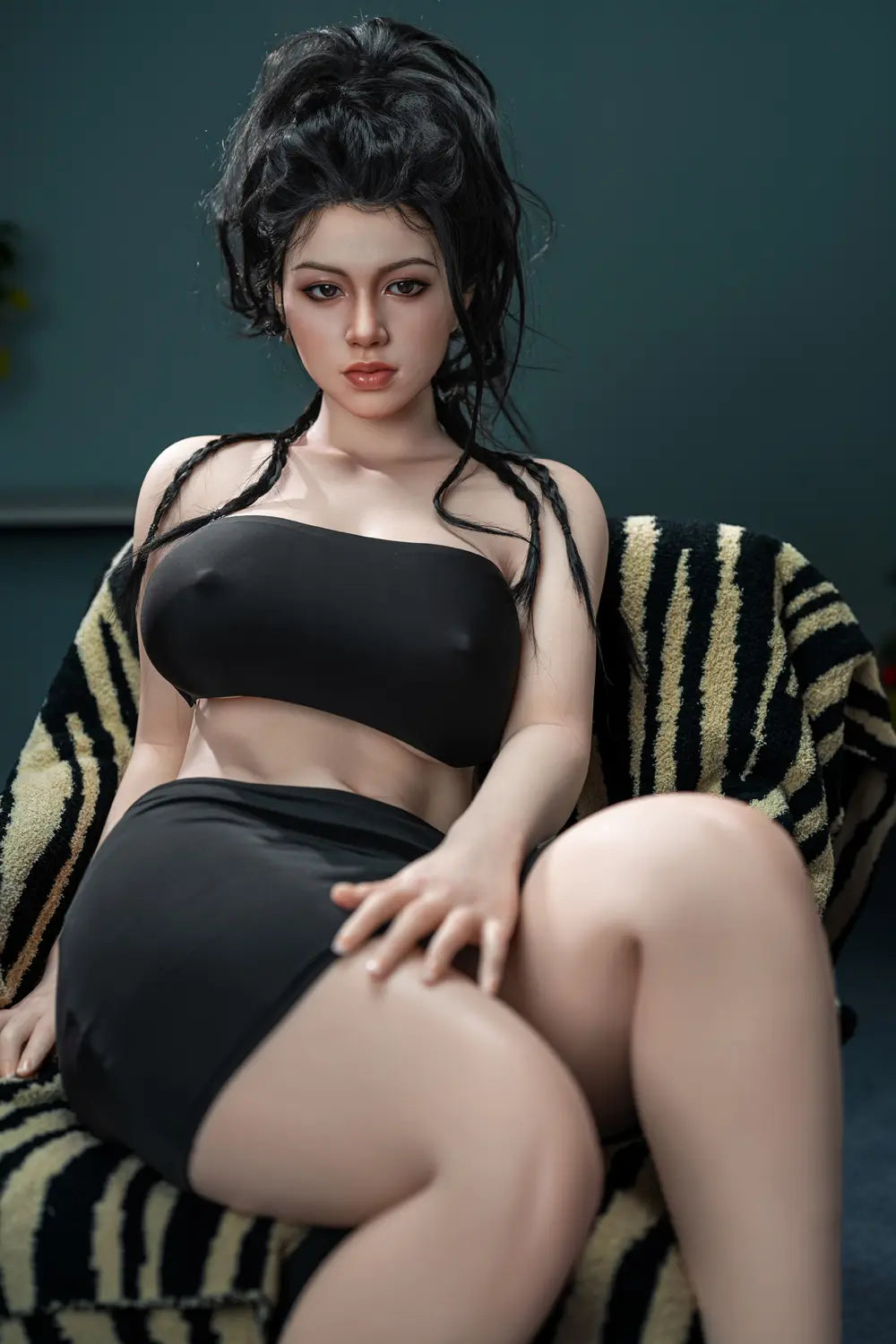 Lifelike Eastern Asian beauty with long black braided hair, wearing black tube top and skirt, sitting confidently on zebra-patterned throw – realistic companion doll at toplovedoll.com